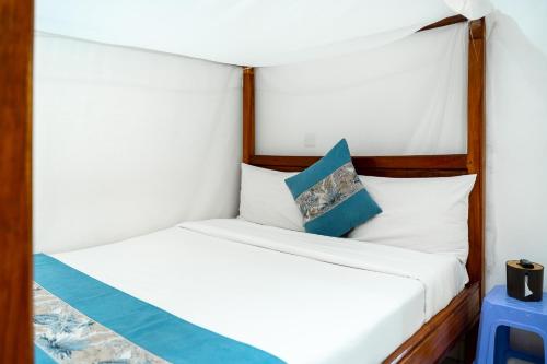 a bedroom with two beds with white and blue pillows at Harry's Kisumu Oasis in Kisumu