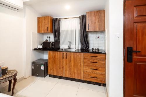 a small kitchen with a sink and a window at Harry's Kisumu Oasis in Kisumu