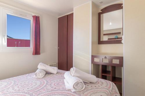 a bedroom with a bed with towels on it at Bungalow Mis Niñas 2 in Conil de la Frontera