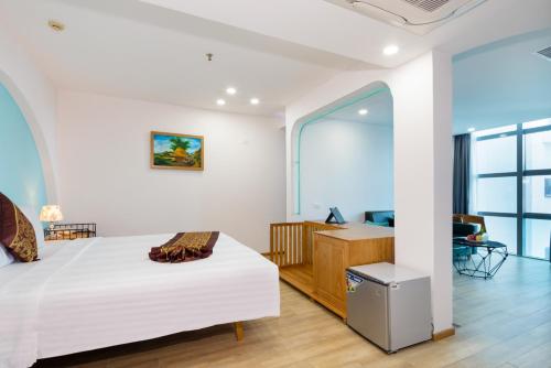 a bedroom with a white bed and a desk at Prime New Hotel in Nha Trang