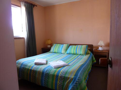 ein Schlafzimmer mit einem Bett mit zwei Handtüchern darauf in der Unterkunft Cabañas y Departamentos Las Golondrinas in Coquimbo