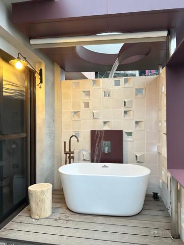 a large white tub in a bathroom with a sink at Jiufen 35 in Jiufen