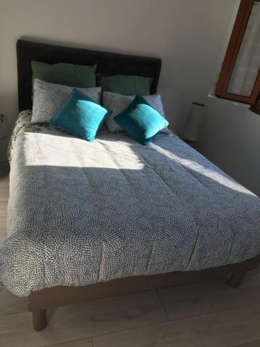 a bed with two blue pillows on top of it at Casa do Sino in Arcos de Valdevez