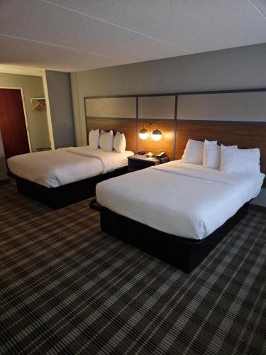 a hotel room with two beds and two lamps at AmericInn by Wyndham Mounds View Minneapolis in Mounds View