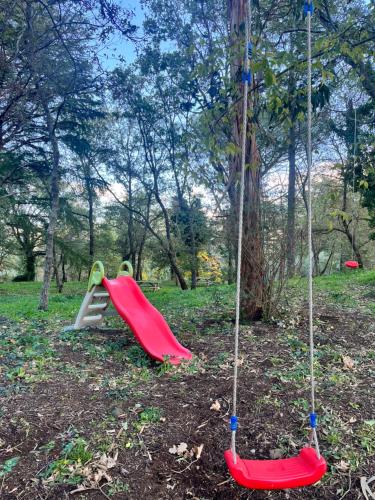 a playground with a slide and a swing set at POGGIO ROSETO in Randazzo