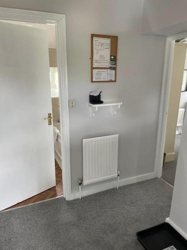 a room with a white wall with a radiator at Upper Dovehouse in Warrington