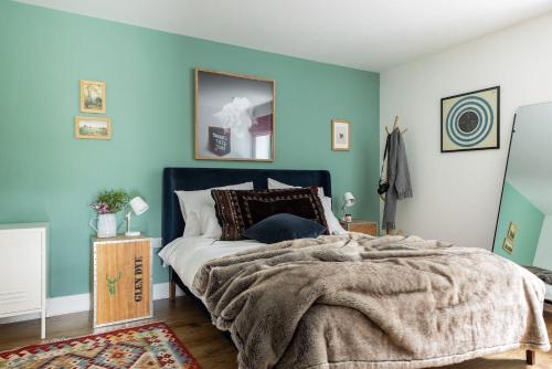 a bedroom with a large bed with blue walls at Number 5 Steading Cottage in Banchory