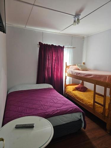 a room with two beds and a table and a desk at Ushuaia de las Nieves B&B in Ushuaia