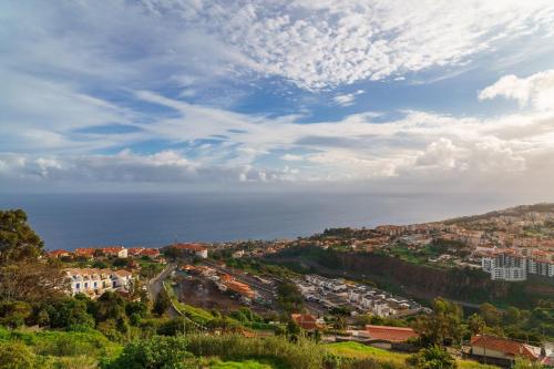 a town on a hill with the ocean in the background at GuestReady - Breathtaking seaview in Caniço in Caniço