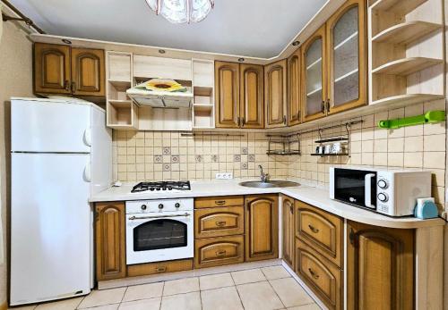 eine Küche mit Holzschränken und einem weißen Kühlschrank in der Unterkunft 1 комнатня квартира на ул Яскрва 7, клиника Рохманова, , пр Слобожанский, 6 городская клиника in Nizhnedneprovsk