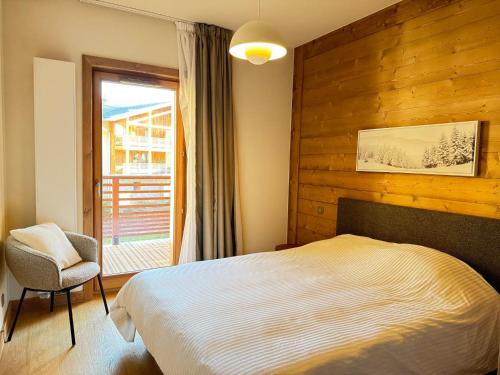 une chambre avec un lit, une chaise et une fenêtre dans l'établissement Les Gets: Apt 4-6pers, centre, proche pistes, terrasse, wifi, parking - FR-1-623-317, aux Gets