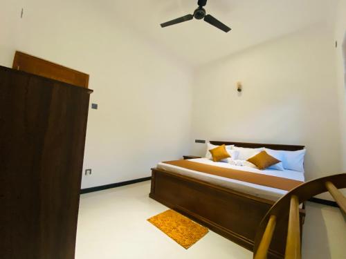 a bedroom with a bed with a ceiling fan at Coco Bay Villa in Galle