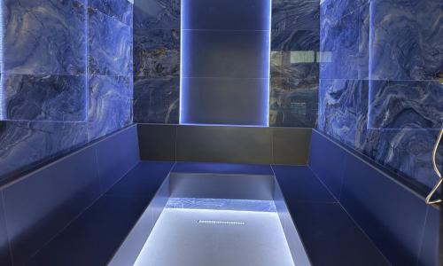 a blue room with a bench in the middle at Predela 2 Aparthotel in Bansko