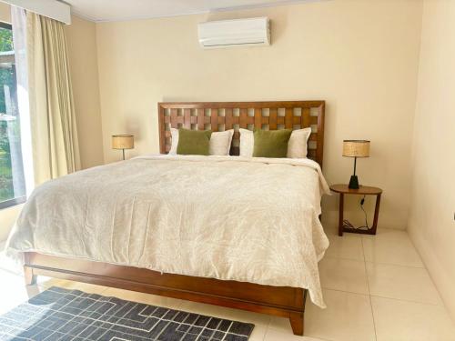 a bedroom with a large bed with green pillows at Arenal by the river in San Francisco