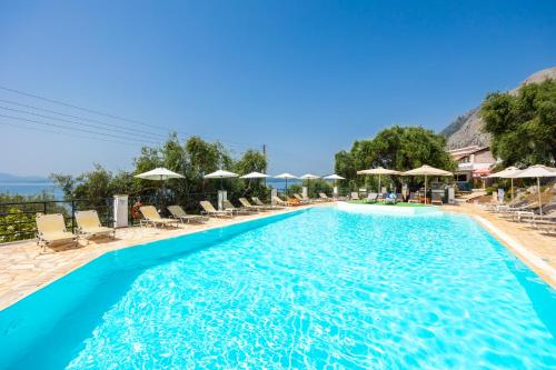 a pool at a resort with chairs and umbrellas at Nissaki Sea View Hotel in Corfu