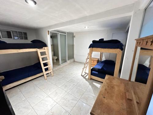 a room with three bunk beds and a table at Suite #1B Cerca de autopista Mex-Qro. in Cuautitlán Izcalli