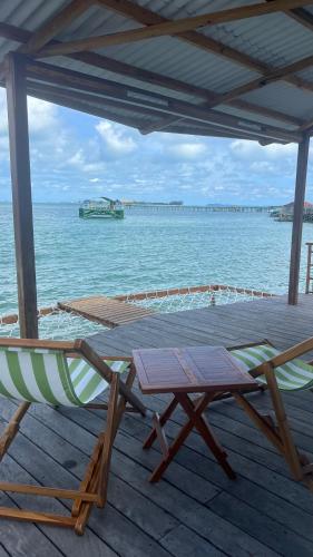 a couple of chairs and a table on a dock at Sadi Beach House in Telukbakau