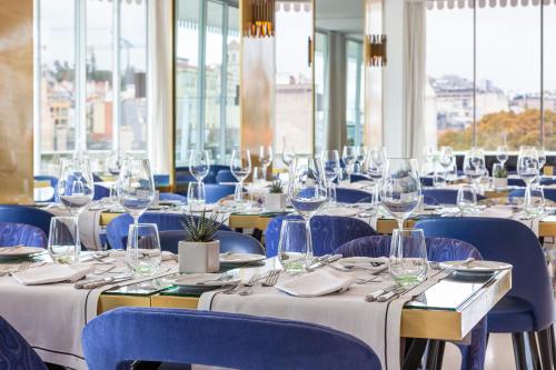 a room with tables and chairs with wine glasses at Altis Avenida Hotel in Lisbon