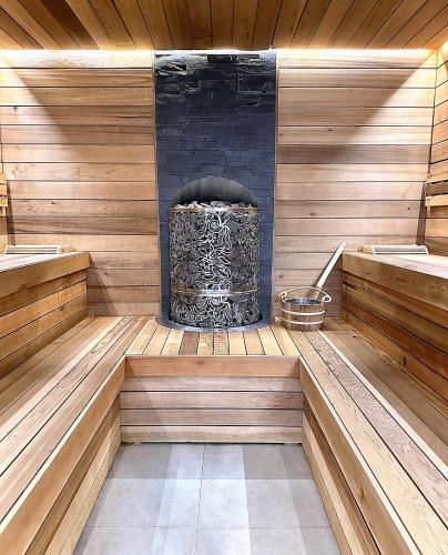 a sauna with a fireplace in the middle at Predela 2 Aparthotel in Bansko