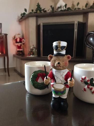 a teddy bear in a top hat next to two coffee cups at Eleousa Apartment Ioannina in Eleoúsa