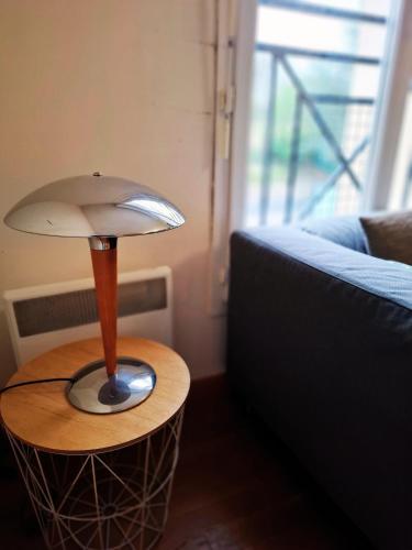 une lampe sur une table à côté d'un canapé dans l'établissement Studio 2 pers avec parking proche Versailles Paris, à Saint-Cyr-lʼÉcole