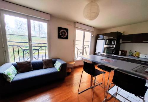 une cuisine et un salon avec un canapé et une table dans l'établissement Studio 2 pers avec parking proche Versailles Paris, à Saint-Cyr-lʼÉcole
