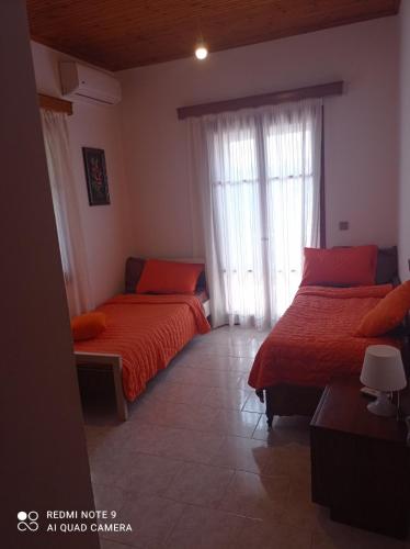 a bedroom with two beds and a window at Ioanna's traditional apartment in Elia Laconias
