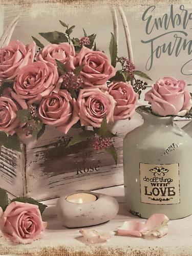 a vase filled with pink roses next to a candle at La dimora di Sandy in Viterbo