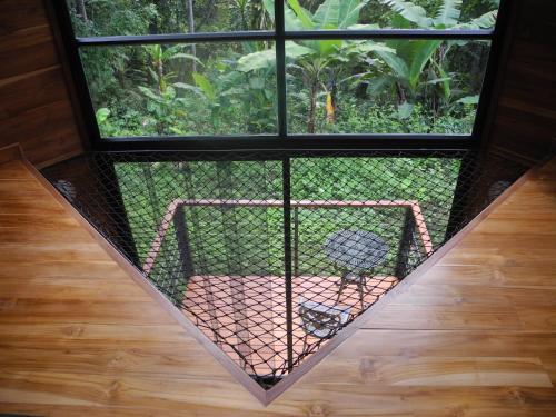 a cage with a bird inside of a window at Mogambo Ecolodge in Viotá