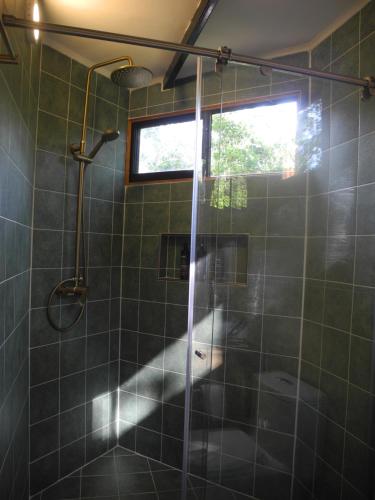 a shower with a glass door in a bathroom at Mogambo Ecolodge in Viotá