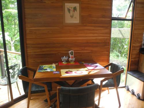 a table and chairs in a room with a wooden wall at Mogambo Ecolodge in Viotá