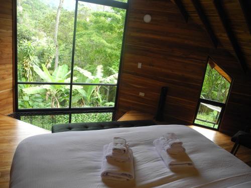 a bedroom with a bed with two slippers on it at Mogambo Ecolodge in Viotá
