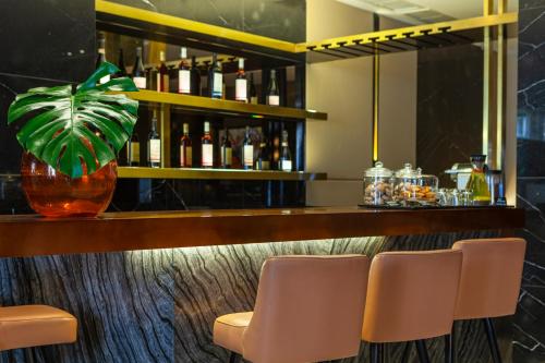 a bar with two chairs and a vase with a plant at Altis Avenida Hotel in Lisbon
