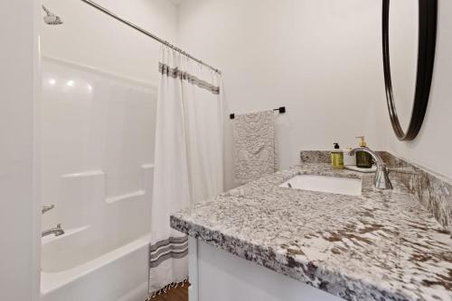 a white bathroom with a sink and a shower at Charming Townhome - New Construction in Lafayette