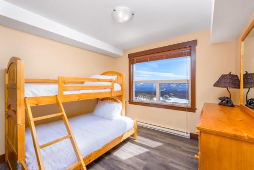 ein Schlafzimmer mit Etagenbetten und einem Schreibtisch mit Fenster in der Unterkunft Stonegate Resort Unit C105 in Kelowna