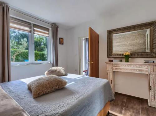 a bedroom with a bed with two pillows on it at Villa Palma Karojba in Karojba