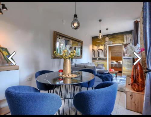 a living room with blue chairs and a table and a couch at Villa Palma Karojba in Karojba