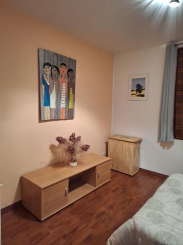 a living room with a table and a painting on the wall at Maison PORTIRAGNES près de la mer et du Canal du Midi in Portiragnes