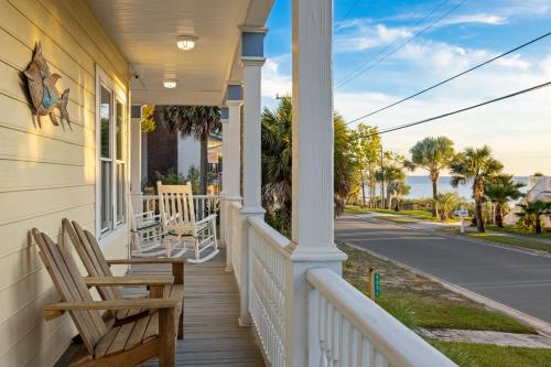 a porch of a house with two chairs at Sea of Cedar Key in Cedar Key