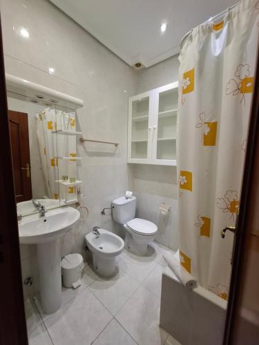 łazienka z 2 toaletami, umywalką i prysznicem w obiekcie Hostal Villamañez w Madrycie