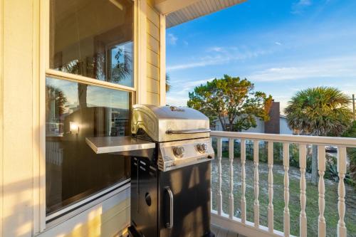 a grill on a porch with a balcony at Sea of Cedar Key in Cedar Key