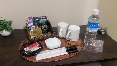 a table with a tray with office supplies and a bottle of water at Hotel The Lotus Bali (Adult Only) in Kawasaki