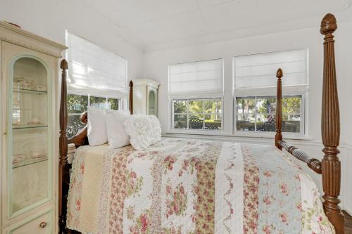 une chambre avec un lit et deux fenêtres dans l'établissement Tyson House Historic Downtown Cottage, à Cedar Key