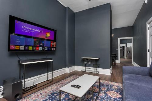 哈里斯堡Flats on Front - Riverfront Gem Fast Wi-Fi 1F的客厅墙上有一台平板电视