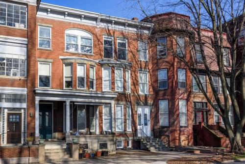 ein rotes Backsteingebäude mit weißen Fenstern auf einer Straße in der Unterkunft Flats on Front - Riverfront Gem Fast Wi-Fi 1F in Harrisburg