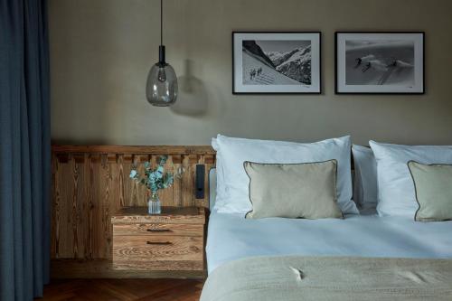 a bedroom with a bed with pillows and a table at Miiro The Mansard in Gstaad