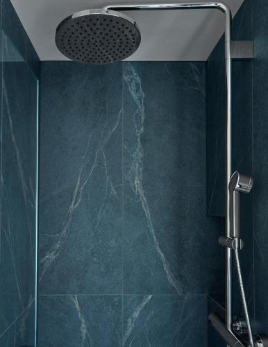 a shower in a bathroom with green walls at Miiro The Mansard in Gstaad