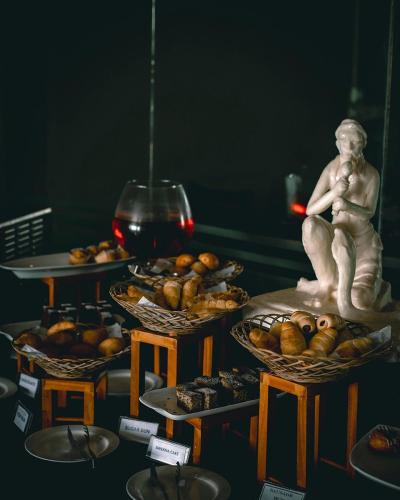 a table topped with baskets of food and a statue at Paradise Beach Club in Mirissa