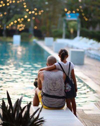 a man and a woman standing next to a swimming pool at Paradise Beach Club in Mirissa