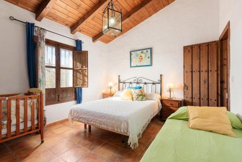 a bedroom with two beds and a crib at Casa Rural La Herradura in Antequera